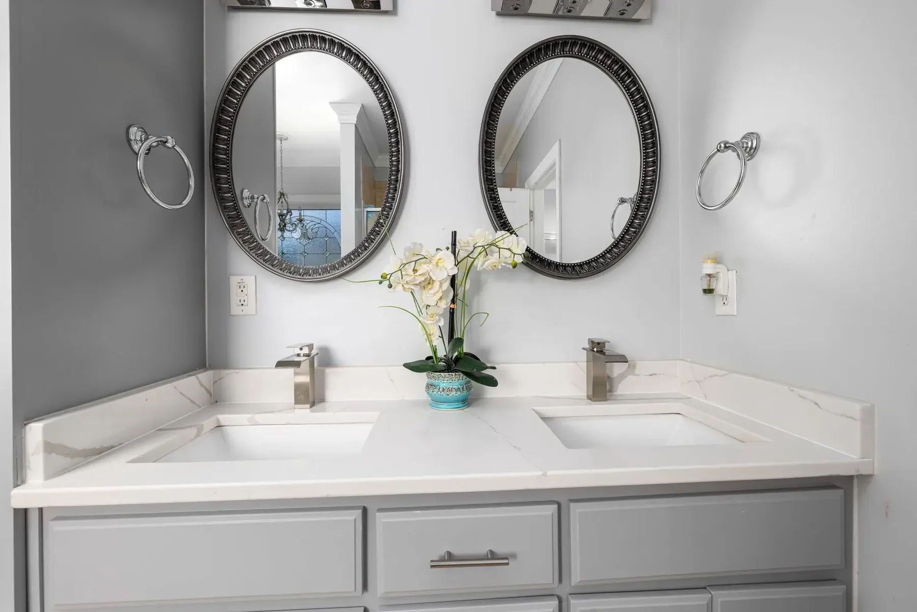 Gray double vanity with white countertop in a bathroom remodel in Lehigh Acres