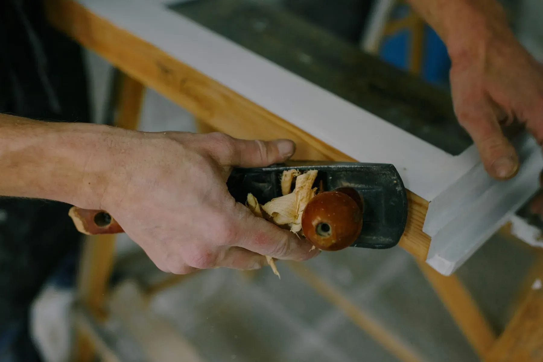 Hand plane shaping white painted trim in a carpentry job in Lehigh Acres